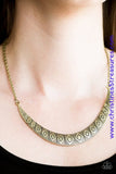 Stamped in tribal inspired patterns, a brass crescent-shaped plate swings from the bottom of a shimmery brass chain, creating a bold pendant below the collar. Features an adjustable clasp closure. Sold as one individual necklace. Includes one pair of matching earrings.  P2TR-BRXX-057XX