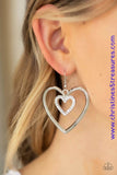 A dainty white rhinestone encrusted heart frame swings from the top of an oversized silver heart frame, creating a charming duo. Earring attaches to a standard fishhook fitting. Sold as one pair of earrings. P5RE-WTXX-445XX