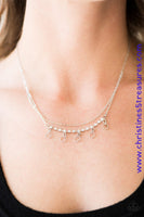 Two shimmery silver chains cascade below the collar in a dainty fashion. A row of shiny serrated hoops cascade from the bottom of a strand of glittery white rhinestone for a modern look. Features an adjustable clasp closure. Sold as one individual necklace. Includes one pair of matching earrings. P2CH-WTXX-024XX