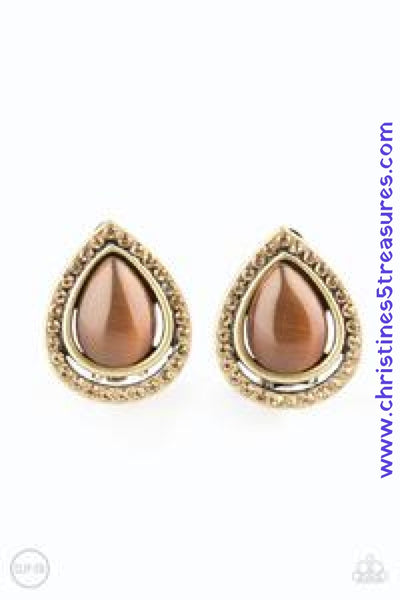 Encrusted in golden topaz rhinestones, a radiant brass ribbon spins around a glowing brown moonstone center, creating a refined teardrop. Earring attaches to a standard clip-on fitting. Sold as one pair of clip-on earrings.  P5CO-BRXX-010XX