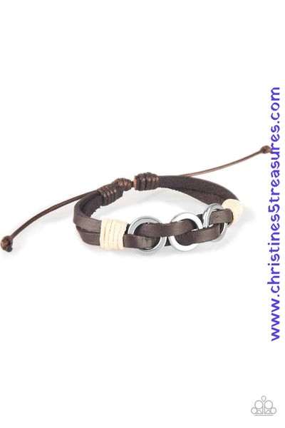 Infused with white twine cording, antiqued silver rings are threaded along strands of brown leather bands for a rustic look. Features an adjustable sliding knot closure. Sold as one individual bracelet.  P9UR-BNXX-397XX   
