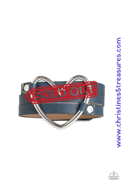 An oversized silver heart frame is studded in place across the center of a spliced blue leather band for a seasonal look. Features an adjustable snap closure. Sold as one individual bracelet.  P9UR-BLXX-146XX