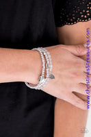 An array of glassy and polished gray beads are threaded along stretchy bands. Infused with silver accents, a collection of silver heart charms and a bead spelling out the word, "love", adorn the beaded strands for a romantic finish. Sold as one set of three bracelets.  P9WH-SVXX-172XX