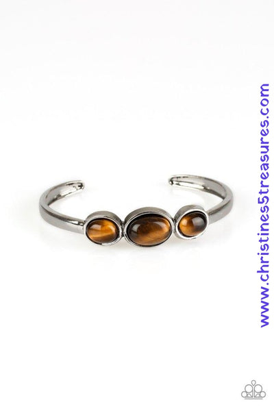 Glowing Tiger's Eye stones are encrusted across the middle of a dainty silver cuff for a seasonal flair. As the stone elements in this piece are natural, some color variation is normal. Sold as one individual bracelet.  P9SE-BNXX-116XX