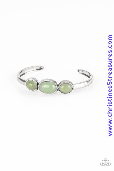 Glassy green stones are encrusted across the middle of a dainty silver cuff for a seasonal flair. As the stone elements in this piece are natural, some color variation is normal. Sold as one individual bracelet.  P9SE-GRXX-106XX