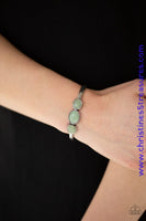 Glassy green stones are encrusted across the middle of a dainty silver cuff for a seasonal flair. As the stone elements in this piece are natural, some color variation is normal. Sold as one individual bracelet.  P9SE-GRXX-106XX