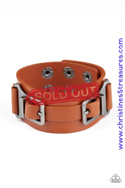 A collection of leather pieces and antiqued gunmetal frames are studded in place across the front of a thick leather band, creating an abstract buckle. Features an adjustable snap closure. Sold as one individual bracelet.