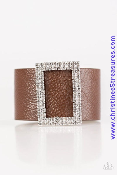 Two rows of dazzling white rhinestones coalesce into a rectangular frame. The glittery frame is threaded along a band of brown leather, creating a stunning centerpiece. Features an adjustable snap closure. Sold as one individual bracelet.  P9DI-URBN-032XX