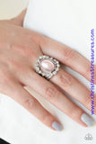 A ring of glassy white rhinestones spins around a pearly pink center, creating a refined statement piece atop the finger. Features a stretchy band for a flexible fit. Featured inside The Preview at ONE Life! Sold as one individual ring.  P4RE-PKXX-197XX