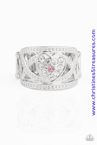 Dotted in dainty silver studs, glistening silver bands weave across the finger. A white rhinestone encrusted silver heart adorns the center, creating a flirtatious centerpiece. A dainty pink rhinestone dots the center for a colorful finish. Features a stretchy band for a flexible fit. Sold as one individual ring.  P4RE-PKXX-207XX