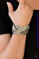 Oversized glassy white rhinestones are encrusted along strands of crisscrossing brown suede, creating a fierce shimmer around the wrist. Features an adjustable snap closure. Sold as one individual bracelet.  P9DI-URBN-045XX