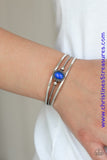 Smooth silver bars flank a textured silver band, coalescing into a layered cuff. A glowing blue cat's eye stone is pressed into the center of the cuff for a whimsical finish. Featured inside The Preview at ONE Life! Sold as one individual bracelet.  P9WH-BLXX-215XX