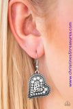 Encrusted in glittery white rhinestones, the center of a heart shaped frame is embossed in a textured heart for a flirty finish. Earring attaches to a standard fishhook fitting. Sold as one pair of earrings. P5WH-WTXX-129XX