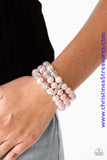 Pinched between white rhinestone encrusted frames, white rhinestone encrusted rings, crystal-beads, and pink pearls are threaded along elastic stretchy bands for a glamorous look. Sold as one individual bracelet.  P9RE-PKXX-128XX