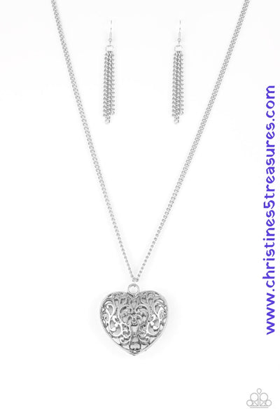 Antiqued vine-like filigree climbs the front and back of a heart-shaped pendant, creating a dramatic 3-dimensional pendant. The vintage inspired pendant swings from the bottom of a lengthened silver chain for a gorgeous tone on tone finish. Features an adjustable clasp closure. Sold as one individual necklace. Includes one pair of matching earrings.   P2WH-SVXX-241XX
