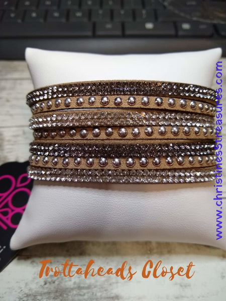 Shiny silver studs and rows of smoky and glittery brown rhinestones are encrusted along strips of tan suede, creating sassy shimmer around the wrist. Features an adjustable snap closure. Sold as one individual bracelet.  P9DI-BRSV-122XX