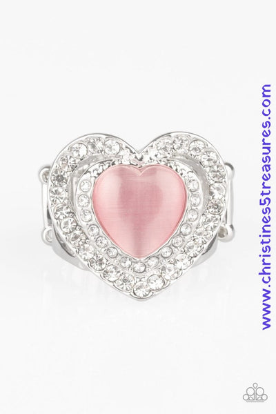 Chiseled into a charming heart shape, a glowing pink cat's eye stone is pressed into the center of two silver heart frames radiating with glassy white rhinestones, creating a romantic centerpiece atop the finger. Features a stretchy band for a flexible fit. Sold as one individual ring.  P4RE-PKXX-208XX